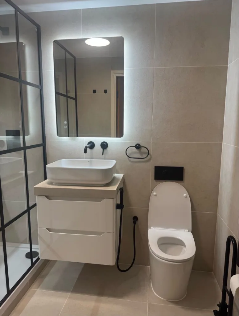 Wall-hung vanity and countertop basin in a refurbished shower room